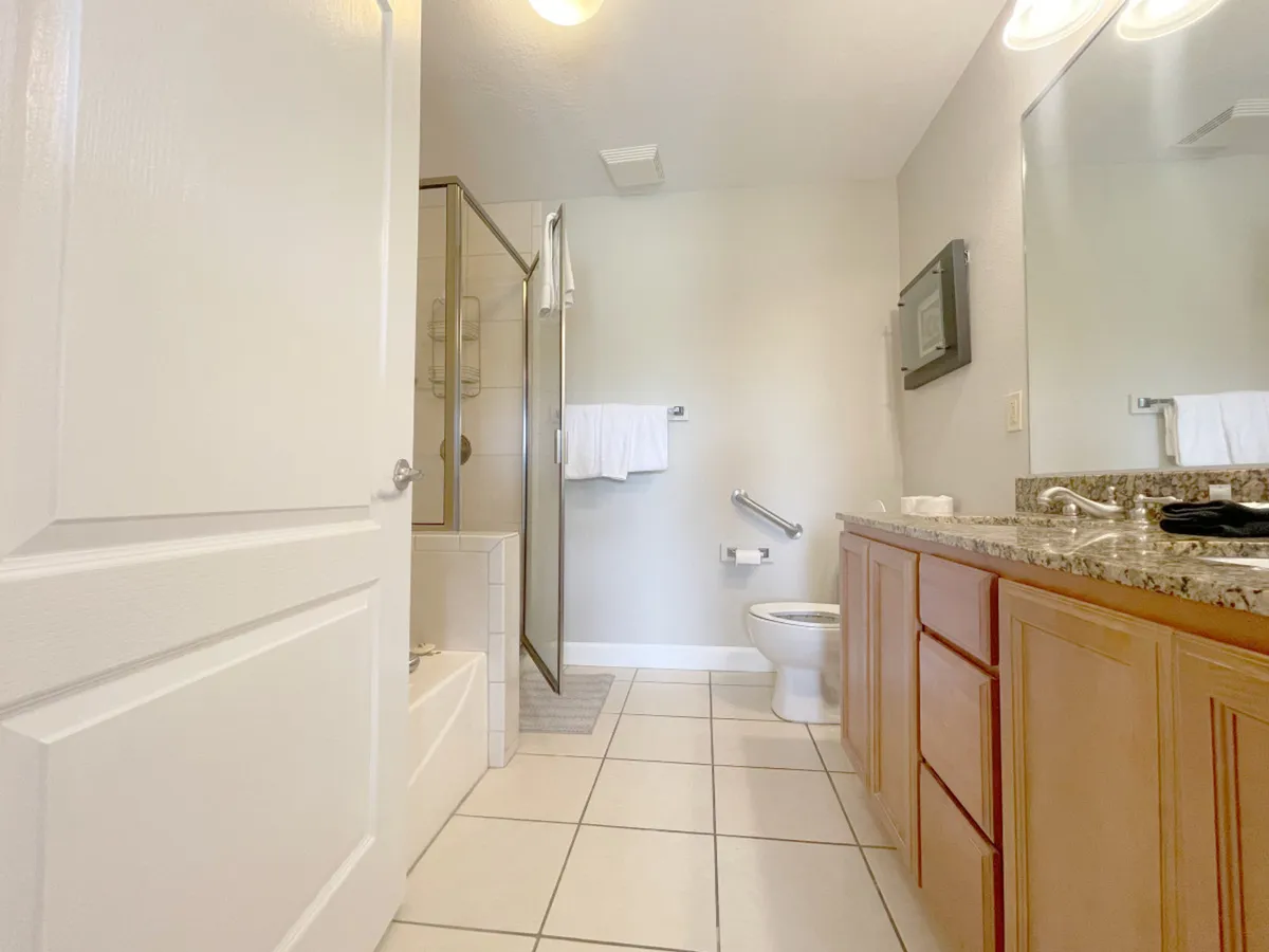 A bright, pristine bathroom with a large shower enclosure, inviting bathtub, and a sleek vanity with sink. The tranquil atmosphere is ideal for relaxation and self-care routines after a day outdoors.