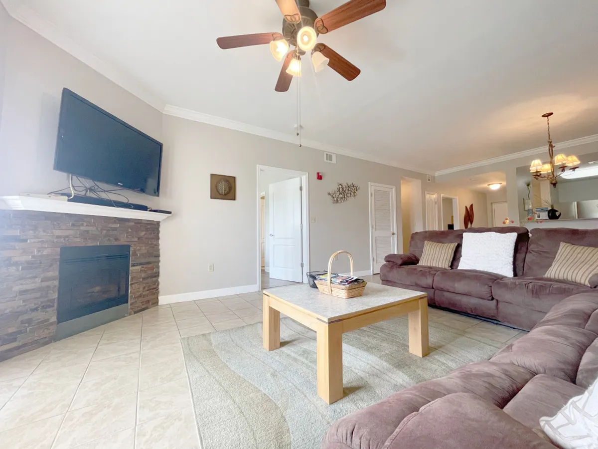 A cozy living area with a comfortable sofa, coffee table, fireplace, and flat-screen television. The scene exudes warmth and relaxation, ideal for evenings spent enjoying complimentary cable TV or connecting online with upgraded WiFi.