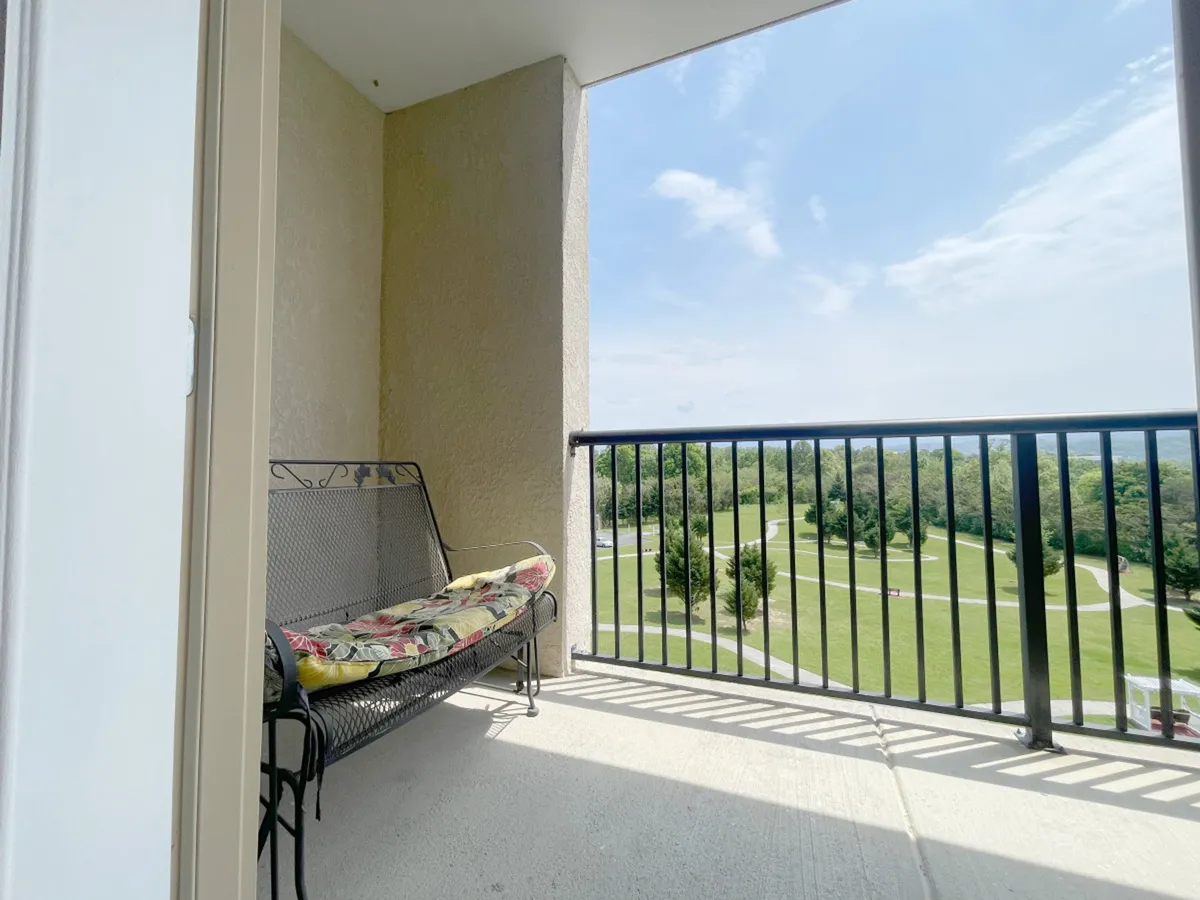 An inviting exterior balcony scene overlooking a lush landscape, with comfortable seating perfect for relaxing and soaking in the views. The setting evokes peaceful moments of family connection, morning coffee, or winding down after an active day.